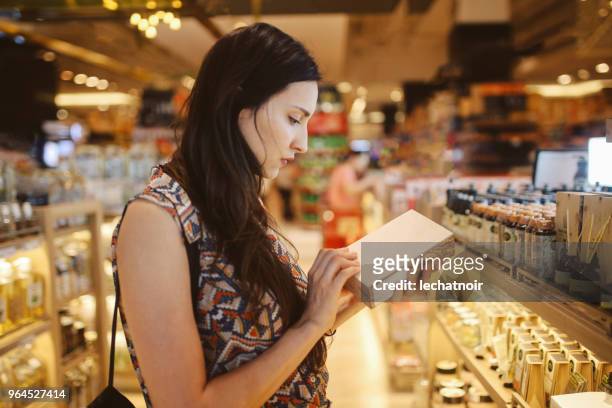 junge frau, die durch die geschäfte im einkaufszentrum bangkok durchsuchen - shopping candid stock-fotos und bilder
