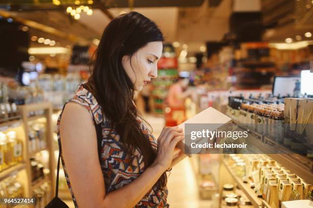 jeune femme en parcourant les magasins dans le centre commercial de bangkok - magasin cosmétique photos et images de collection