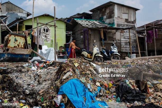 Plastic trash left behind by the tide mars the beach of a fishing village on the northern coast on May 31, 2018 in Jakarta, Indonesia. Indonesia has...