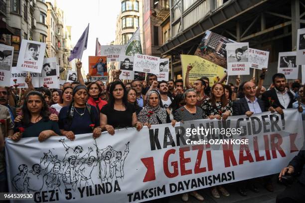 People demonstrate behind a banner reading "Darkness will go, Gezi will stay" on May 31, 2018 in Istanbul, to mark the fifth anniversary of the start...