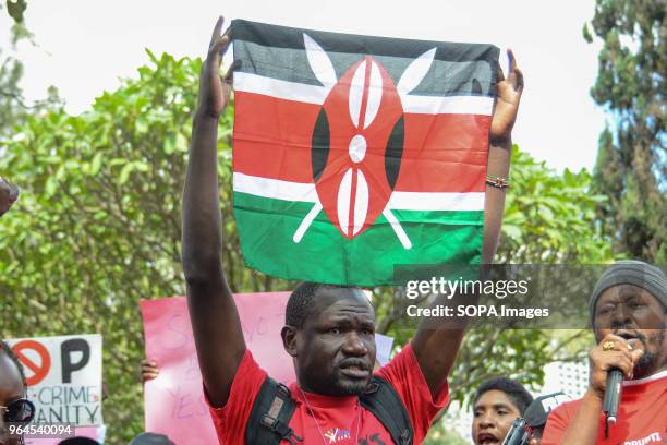 Protestor carry a Kenyan Flag as citizens protest in the streets of the capital city Nairobi. Protesters took to the streets to call on the...