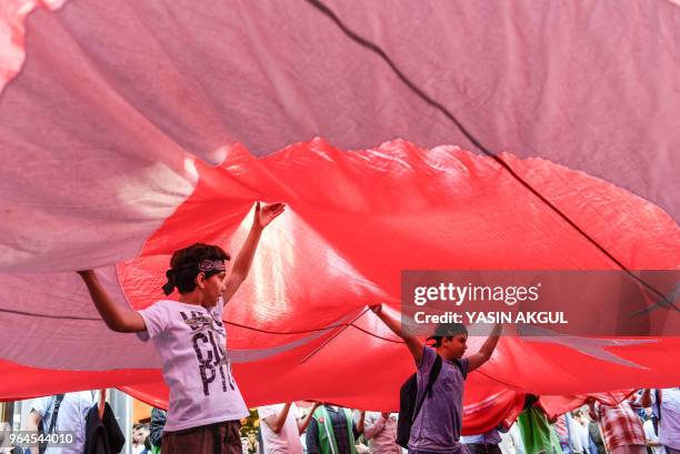 Demonstrators chant slogans as they march with a giant Turkish national flag on May 31, 2018 at Istiklal avenue in Istanbul, to mark the 8th...