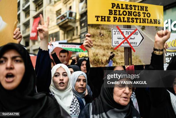 Demonstrators hold signs and flash the victory sign on May 31, 2018 at Istiklal avenue in Istanbul, during a march to mark the 8th anniversary of a...