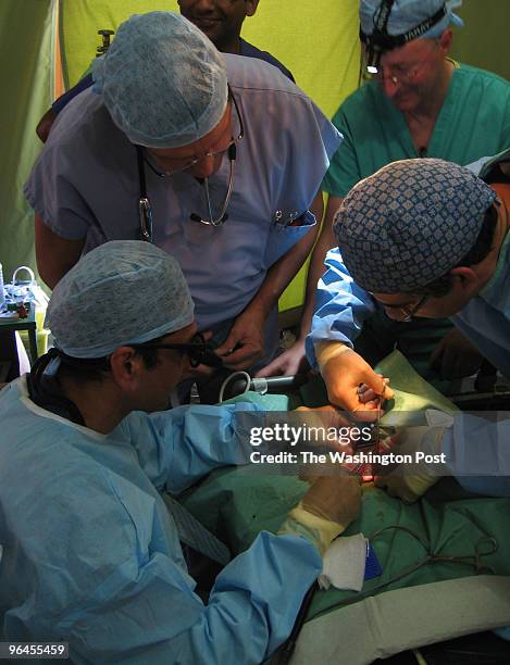 Clockwise from lower left, Merlin's plastic surgeon, Waseem Saeed, wearing surgical loupes, operates on three-month-old Landina Seignon, while...