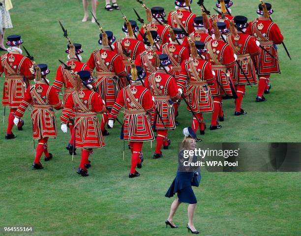 Guest smiles after taking pictures of Yeoman Warders walking past as Queen Elizabeth II hosts a Garden Party at Buckingham Palace on May 31, 2018 in...