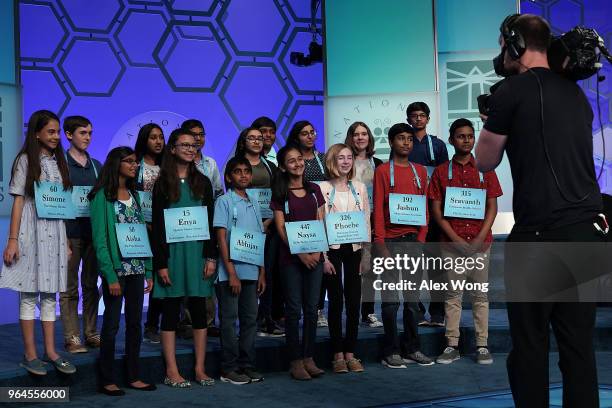Spellers who have advanced to the evening rounds pose for a group picture after round eight of the 91st Scripps National Spelling Bee at the Gaylord...