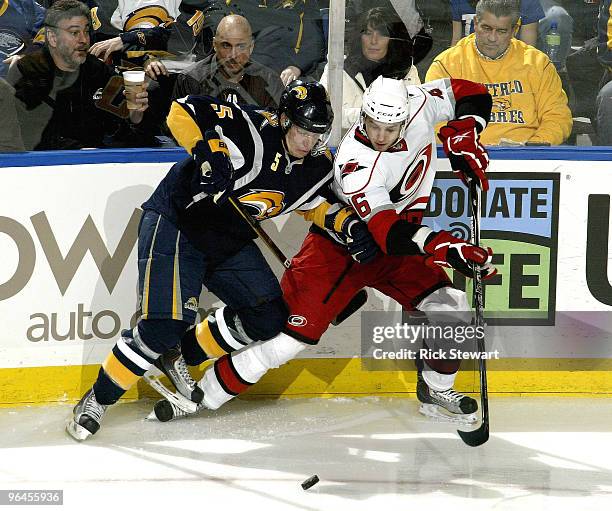 Toni Lydman of the Buffalo Sabres and Brandon Sutter of the Carolina Hurricanes battle for position on the puck at HSBC Arena on February 5, 2010 in...