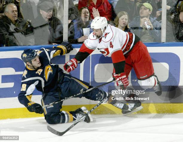 Paul Gaustad of the Buffalo Sabres is checked by Aaron Ward of the Carolina Hurricanes at HSBC Arena on February 5, 2010 in Buffalo, New York.