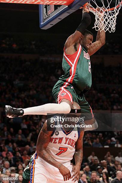 Hakim Warrick of the Milwaukee Bucks swings on the ring after dunking on Al Harrington of the New York Knicks at Madison Square Garden February 5,...