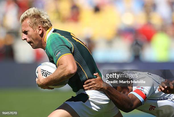Marius Schoeman of South Africa is tackled by Niumala Rokobuli of Fiji in the Quarter Final Cup match between Fiji and South Africa during day two of...