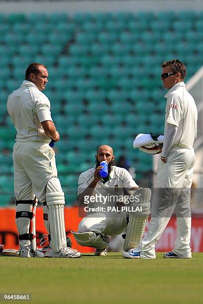 South African cricketers Jacques Kallis, Hashim Amla and Johan Botha take a break on the first day of the first cricket Test match between India and...