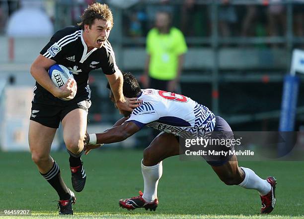 Kurt Baker of New Zealand is tackled by Paul Chan Tung of Samoa in the Semi Final Cup match between New Zealand and Samoa during day two of the...