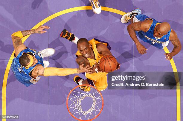 Kobe Bryant of the Los Angeles Lakers goes up for a shot between Kenyon Martin and Chauncey Billups of the Denver Nuggets at Staples Center on...