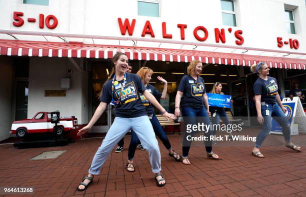 Walmart associates dance in front of Sam Walton's original 5 & 10 store, now a museum, during the annual shareholders meeting event on May 31, 2018...