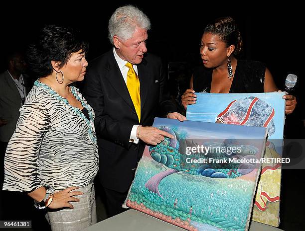 Debra Lee, Chairman & CEO of BET, President Bill Clinton, and actress Queen Latifah look at Haitian paintings backstage at the BET SOS Saving...