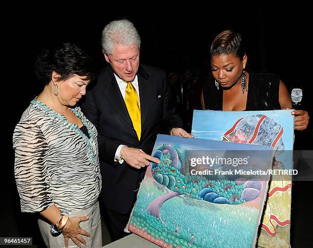 Debra Lee, Chairman & CEO of BET, former President Bill Clinton, and actress Queen Latifah look at Haitian paintings backstage at the BET SOS Saving...