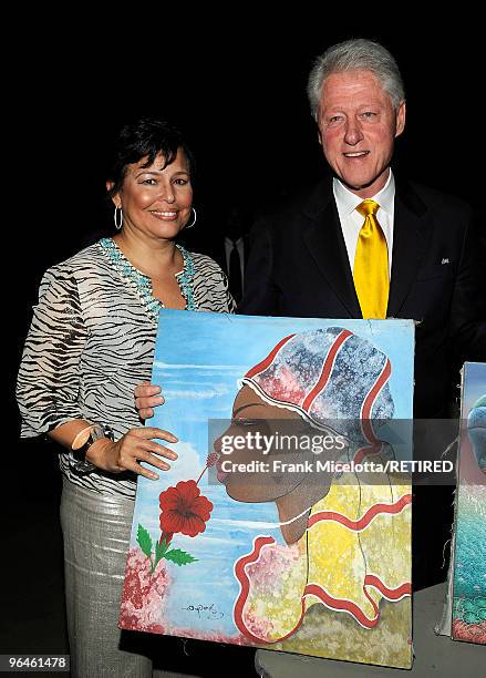 Debra Lee, Chairman & CEO of BET and former President Bill Clinton hold a Haitian painting backstage at the BET SOS Saving Ourselves - Help for Haiti...