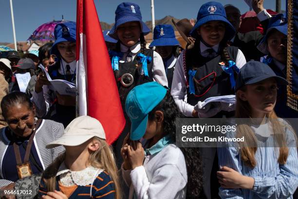 Children hide their faces from the sun as Corpus Christi is celebrated in Plaza De Armas on May 31, 2018 in Cusco, Peru. Thousands of members of the...