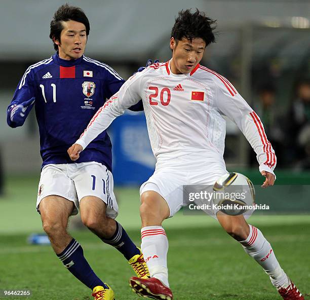 Keiji Tamada of Japan and Hao Rong of China compete for the ball during the East Asian Football Championship 2010 match between Japan and China at...