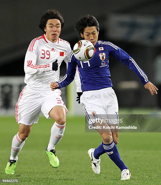 Kengo Nakamura of Japan and Xuri Zhao of China compete for the ball during the East Asian Football Championship 2010 match between Japan and China at...