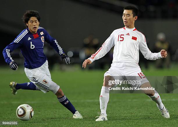 Atsuto Uchida of Japan and Hao Yang of China compete for the ball during the East Asian Football Championship 2010 match between Japan and China at...