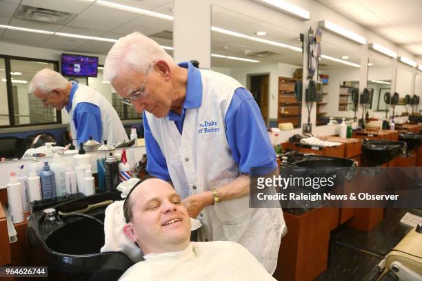 David Fowler, the main barber at Duke Barbershop, washes longtime customer Adam Connor's hair on May 25, 2018. Fowler has cut hair there for over 50...