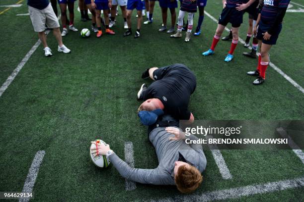 Welsh Rugby Union player Samson Lee demonstrates a tackle on teammate Rhys Patchell while participating in a workshop for youth rugby players at the...
