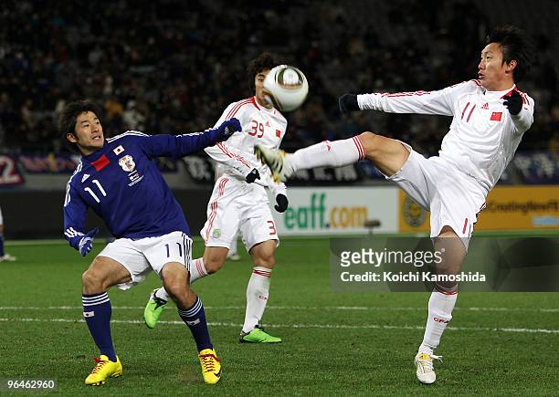 Keiji Tamada of Japan and Bo Qu of China compete for the ball during the East Asian Football Championship 2010 match between Japan and China at...