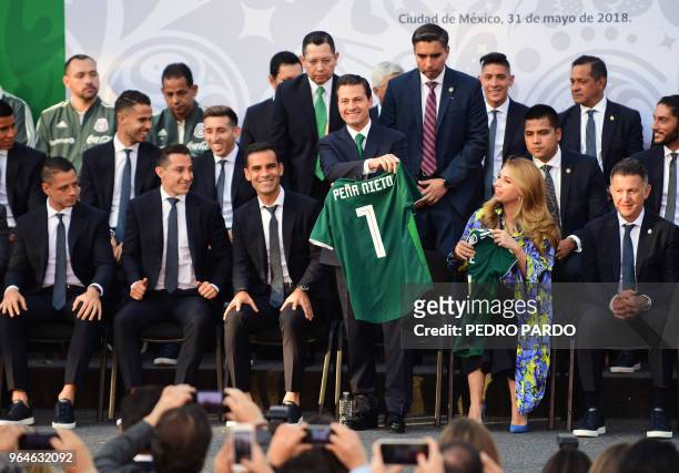 Mexican President Enrique Pena Nieto holds up the national jersey next to Mexico's national football team player Rafael Marquez , First Lady Angelica...