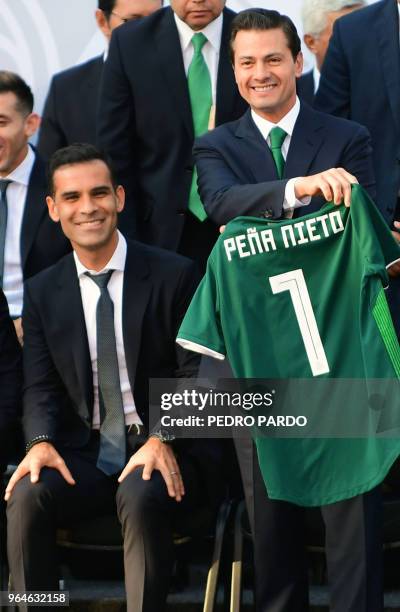 Mexican President Enrique Pena Nieto smiles next to Mexican player Rafael Marquez, after receiving the Mexican national football team jersey with his...