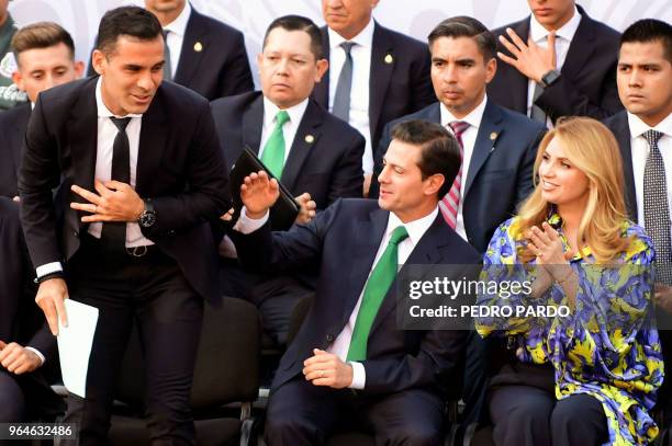 Mexican President Enrique Pena Nieto gestures flanked by Mexico's national football team player Rafael Marquez and his wife Angelica Rivera, during a...