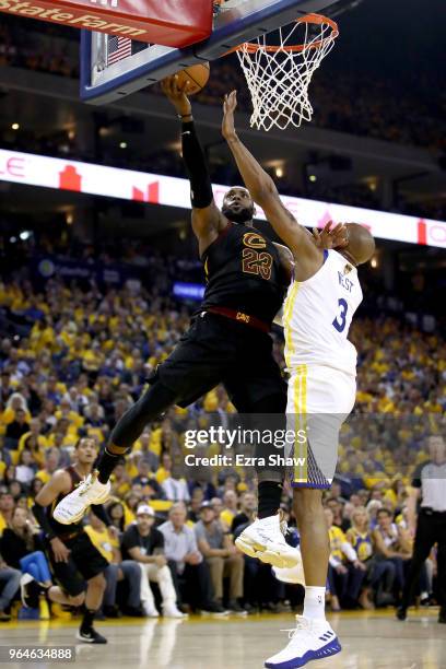 LeBron James of the Cleveland Cavaliers attempts a layup over David West of the Golden State Warriors in Game 1 of the 2018 NBA Finals at ORACLE...