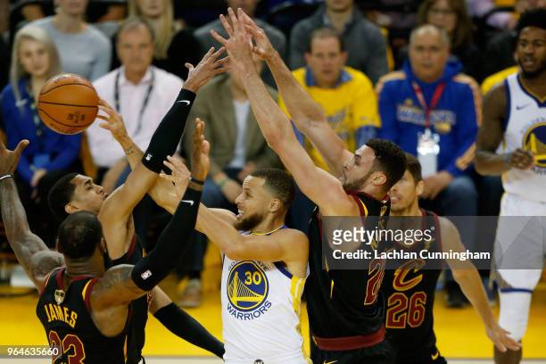 Stephen Curry of the Golden State Warriors attempts to pass around LeBron James, Jordan Clarkson and Larry Nance Jr. #22 of the Cleveland Cavaliers...