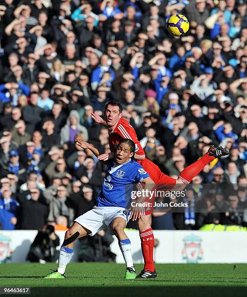 Jamie Carragher of Liverpool competes with Steven Pienaar of Everton during the Barclays Premier League match between Liverpool and Everton at...