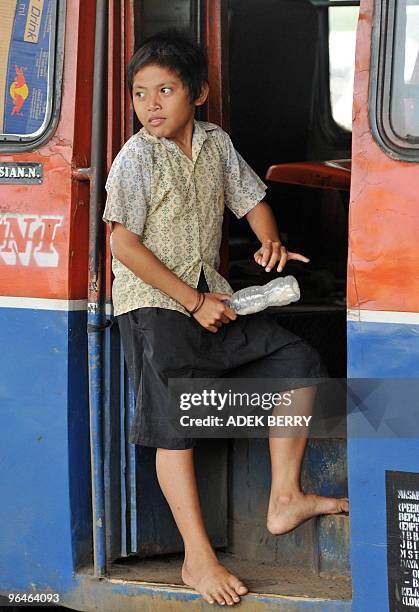 To go with AFP story by Glenda Kwek: INDONESIA-CHILDREN-CRIME-MURDER-POVERTY Teguh alias Acong sings on a mini bus at the Coca-Cola Prapatan in...