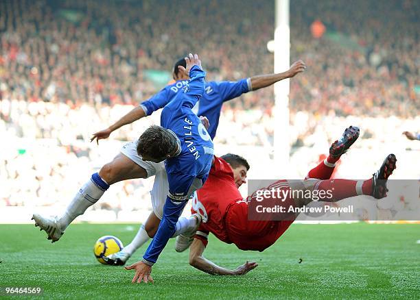 Steven Gerrard captain of Liverpool is taken out by Phil Neville captain of Everton during the Barclays Premier League match between Liverpool and...