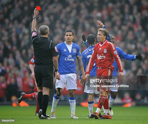 Referee Martin Atkinson shows a red card to Steven Pienaar of Everton during the Barclays Premier League match between Liverpool and Everton at...