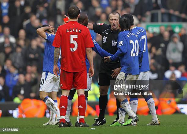 Referee Martin Atkinson shows a red card to Steven Pienaar of Everton during the Barclays Premier League match between Liverpool and Everton at...