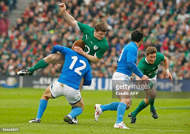Ireland fly half Ronan O'Gara vies with Italy fly half Craig Gower as Ireland captain Brian O'Driscoll is tackled by Italy centre Gonzalo Garcia...