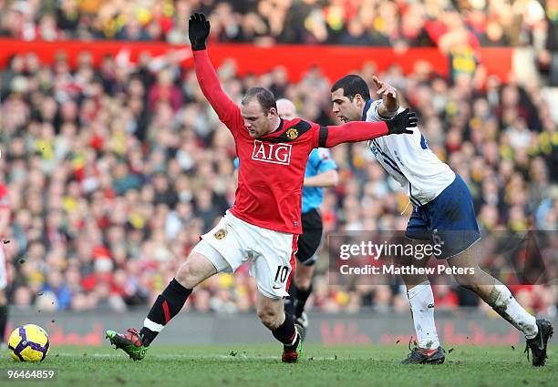 Wayne Rooney of Manchester United clashes with Tal Ben Haim of Portsmouth during the FA Barclays Premier League match between Manchester United and...