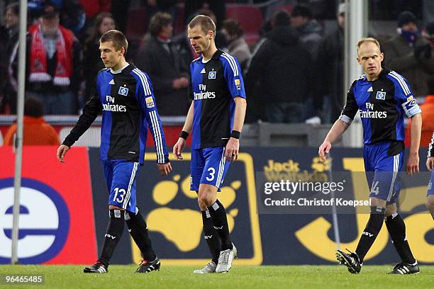 Robert Tesche, David Rozehnal and David Jarolim of Hamburg look dejected after the the 3-3 draw of the Bundesliga match between 1. FC Koeln and...