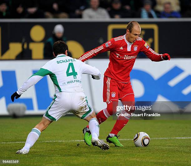 Arjen Robben of Muenchen is challenged by Marcel Schaefer of Wolfsburg during the Bundesliga match between Vfl Wolfsburg and FC Bayern Muenchen at...