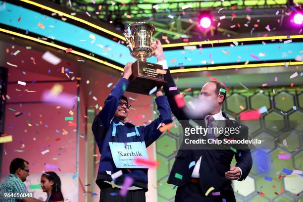 Karthik Nemmani poses with the championship trophy and E.W. Scripps Company CEO Adam Symson after Nemmani correctly spelled the word 'koinonia' to...