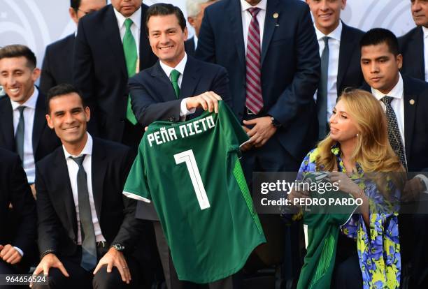 Mexican President Enrique Pena Nieto smiles next to Mexican player Rafael Marquez, after receiving the Mexican national football team jersey with his...