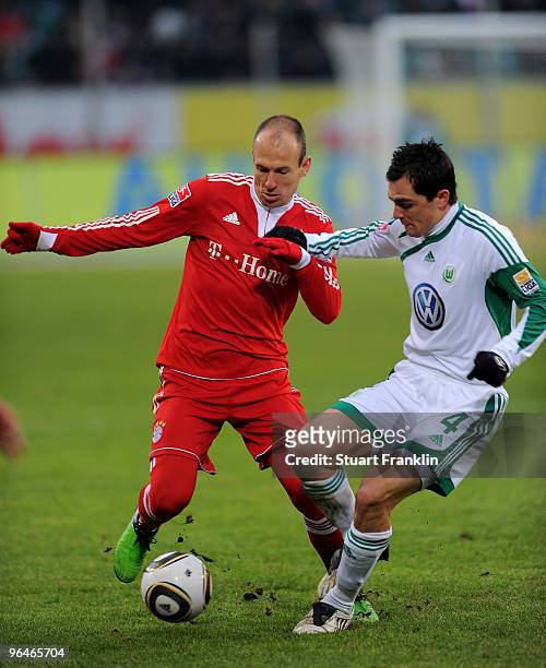 Arjen Robben of Muenchen is challenged by Marcel Schaefer of Wolfsburg during the Bundesliga match between Vfl Wolfsburg and FC Bayern Muenchen at...