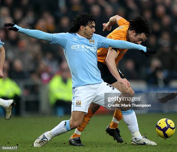 Stephen Hunt of Hull City tangles with Carlos Tevez of Manchester City during the Barclays Premier League match between Hull City and Manchester City...