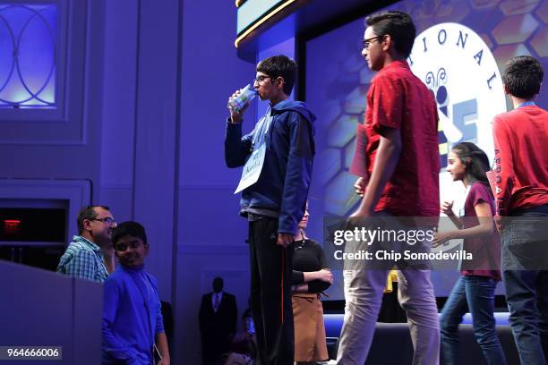 Karthik Nemmani drinks coconut water during a break in the last rounds of the 91st Scripps National Spelling Bee at the Gaylord National Resort and...