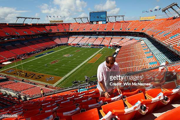 Sun Life Stadium worker Lance Cantor readies seats in the upper deck of the stadium February 6, 2010 in Miami, Florida. Super Bowl XLIV between the...