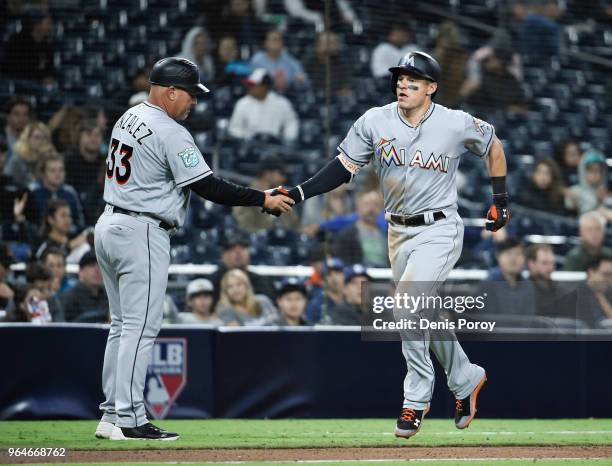 Derek Dietrich of the Miami Marlins is congratulated by Fredi Gonzalez after hitting a solo home run during the eighth inning of a baseball game...