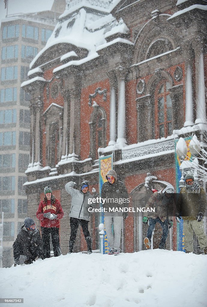 Passers-by throw snowballs from a mound